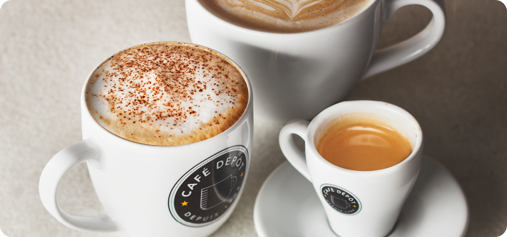 Three coffee cups, including a cappuccino and espresso, showcasing latte art.