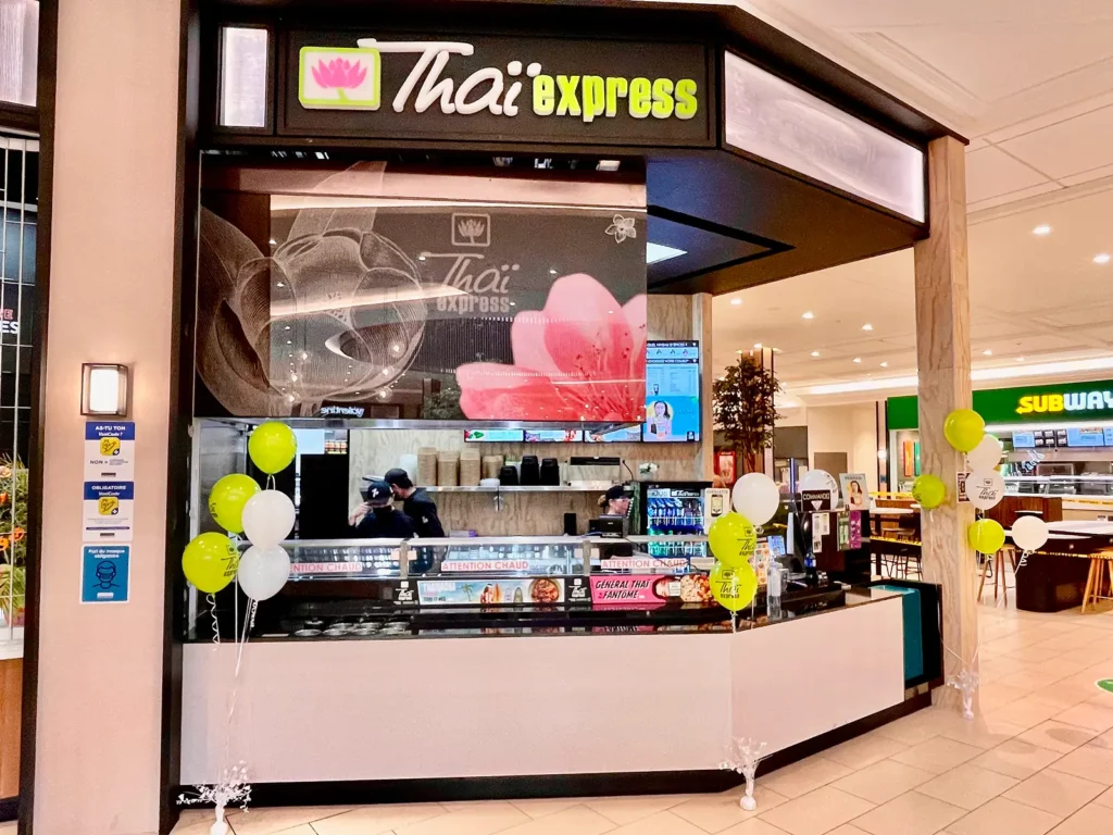 Thaï Express franchise location in a mall, featuring modern design, branded signage, and festive balloons celebrating the brand