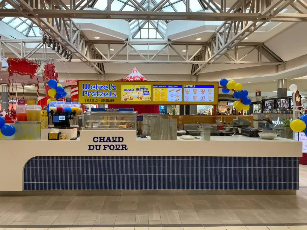Wetzel's Pretzels kiosk inside a shopping mall showcasing the brand's vibrant and welcoming design