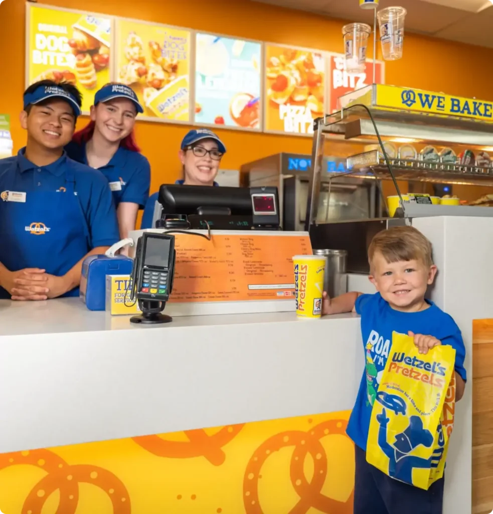 Wetzel's Pretzels grand opening with happy staff and customers enjoying the brand's offerings
