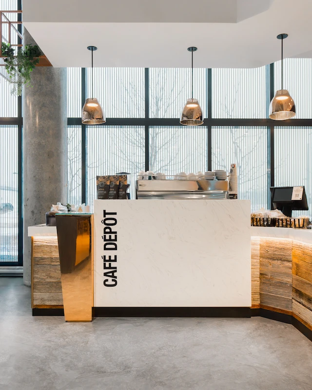 Café Dépôt store counter featuring the brand's prominent logo and inviting café atmosphere.